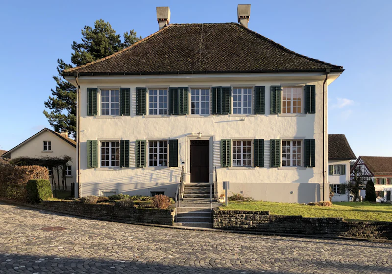Einfamilienhaus mit Fensterläden unter blauem Himmel