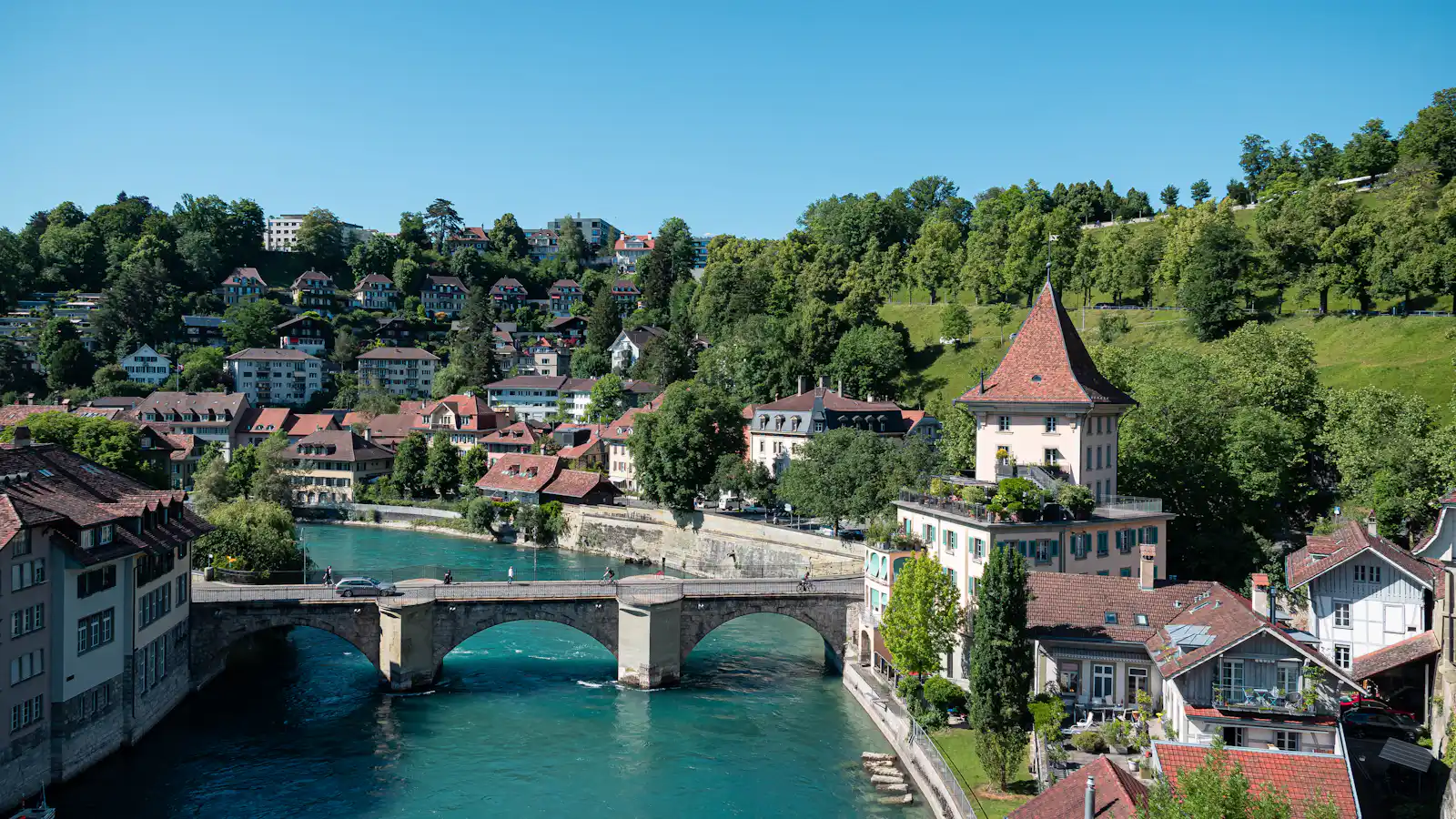 Steinbrücke über die Aare mit Wohnhäusern am Hang – Immobilie verkaufen in Bern